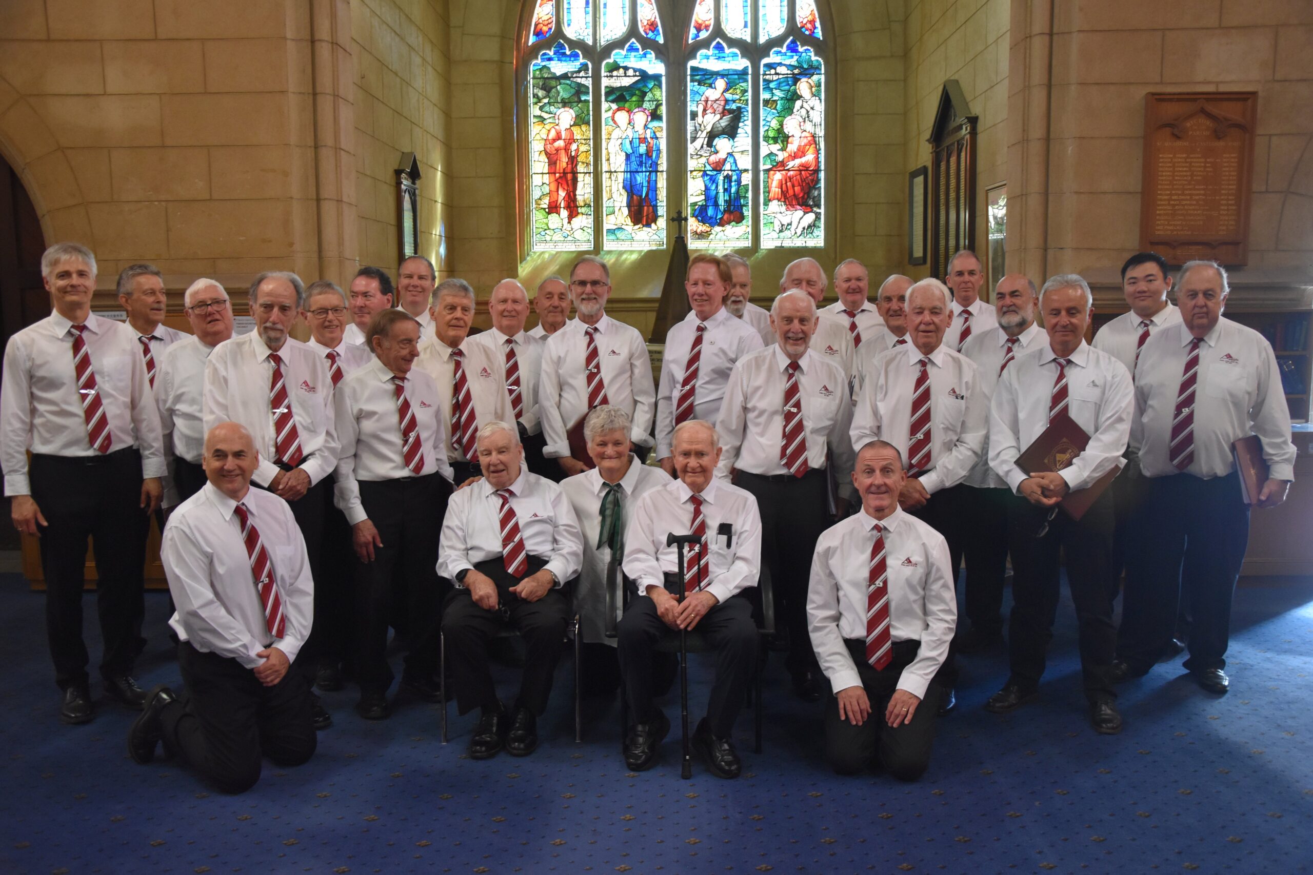 A large group of men in white shirts and ties standing in a church.