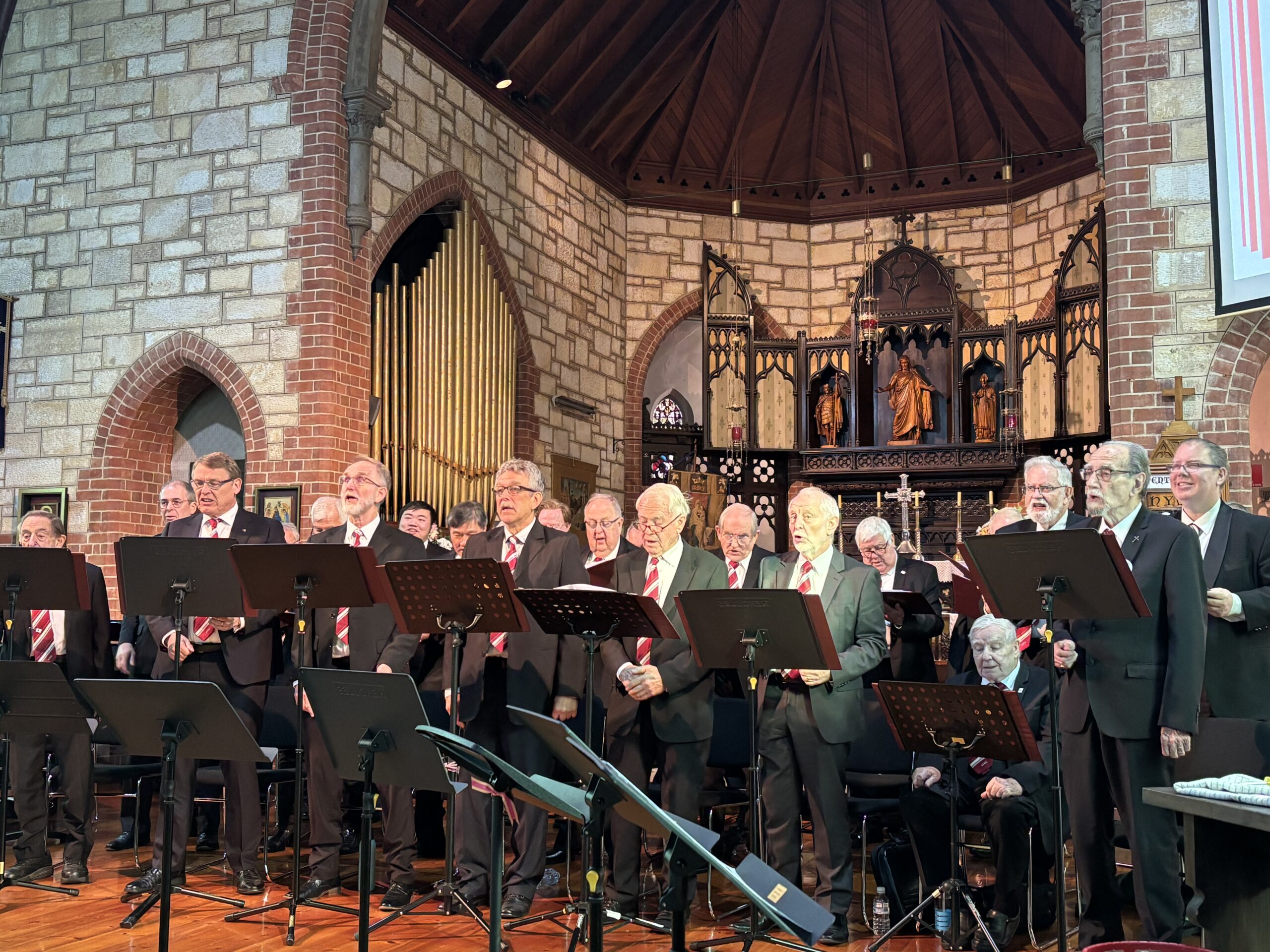 Group of men in suits standing in front of a church altar and singing.